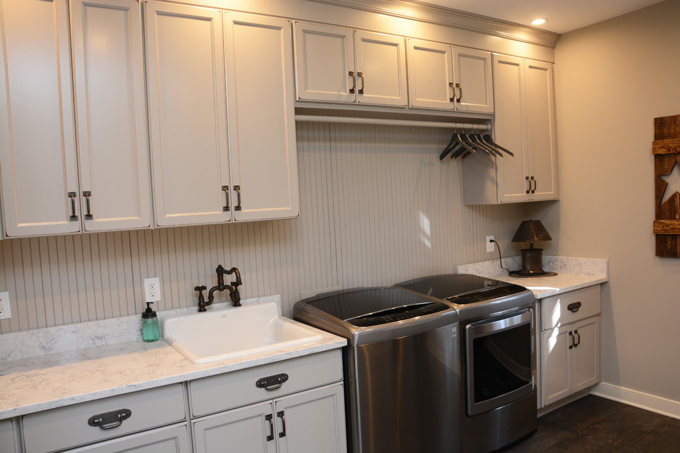 Design ideas for a large traditional galley utility room in Baltimore with a single-bowl sink, recessed-panel cabinets, grey cabinets, quartz benchtops, grey walls, a side-by-side washer and dryer, brown floor and white benchtop.