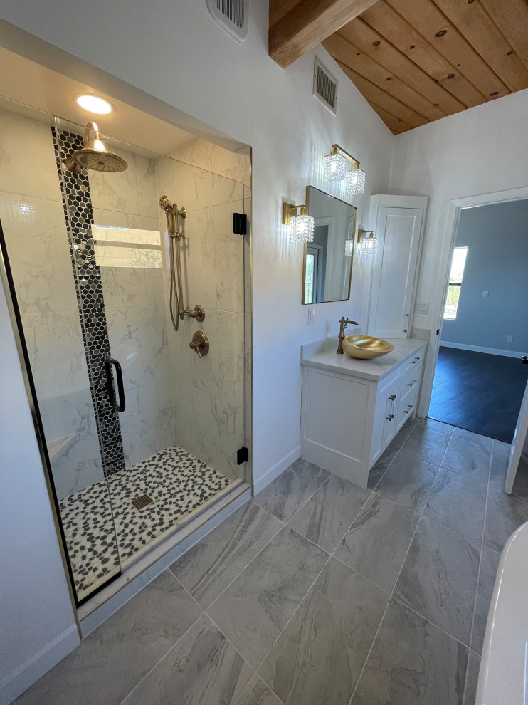 Пример оригинального дизайна: главная ванная комната среднего размера в стиле фьюжн с фасадами в стиле шейкер, белыми фасадами, ванной на ножках, душем в нише, раздельным унитазом, черно-белой плиткой, керамогранитной плиткой, белыми стенами, полом из керамогранита, настольной раковиной, столешницей из искусственного кварца, серым полом, душем с распашными дверями, белой столешницей, нишей, тумбой под одну раковину, встроенной тумбой, балками на потолке и панелями на стенах