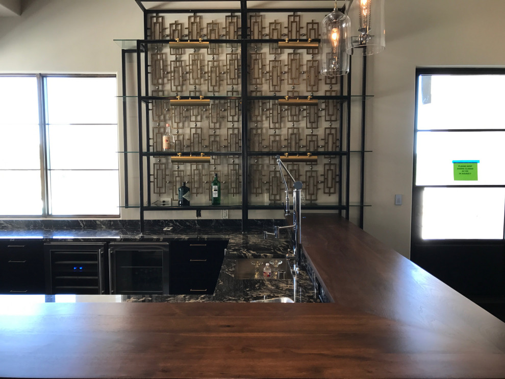 Inspiration for a mid-sized midcentury l-shaped seated home bar in Austin with an integrated sink, wood benchtops, grey splashback, glass tile splashback and brown benchtop.