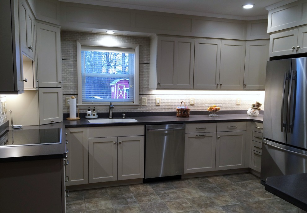 Inspiration for a mid-sized transitional u-shaped linoleum floor eat-in kitchen remodel with an integrated sink, recessed-panel cabinets, white cabinets, solid surface countertops, white backsplash, ceramic backsplash, stainless steel appliances and a peninsula