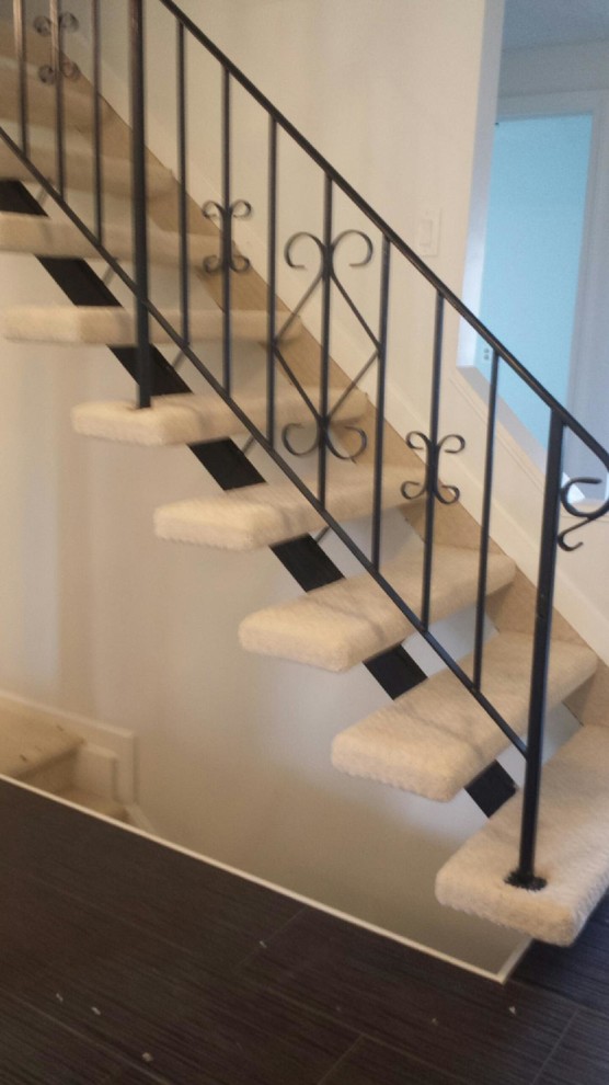 This is an example of a mid-sized traditional carpeted l-shaped staircase in New York with open risers.