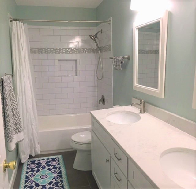 This is an example of a large traditional master bathroom in DC Metro with recessed-panel cabinets, white cabinets, an alcove tub, an alcove shower, a two-piece toilet, white tile, subway tile, green walls, dark hardwood floors, an undermount sink, marble benchtops, brown floor and a shower curtain.