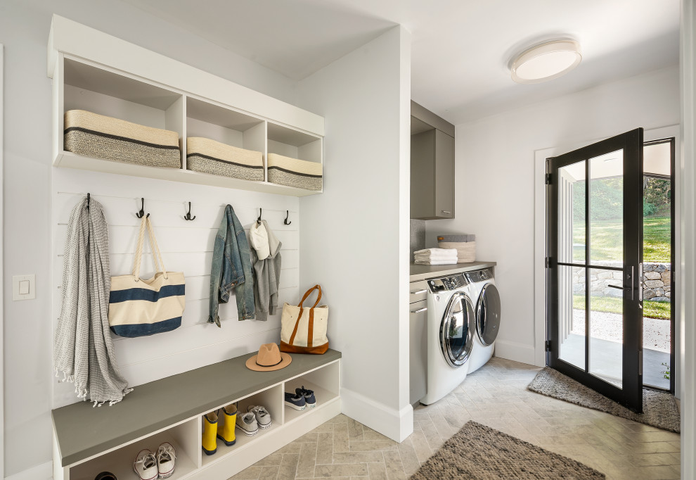 This is an example of a large contemporary laundry room in New York with white walls, porcelain floors and beige floor.