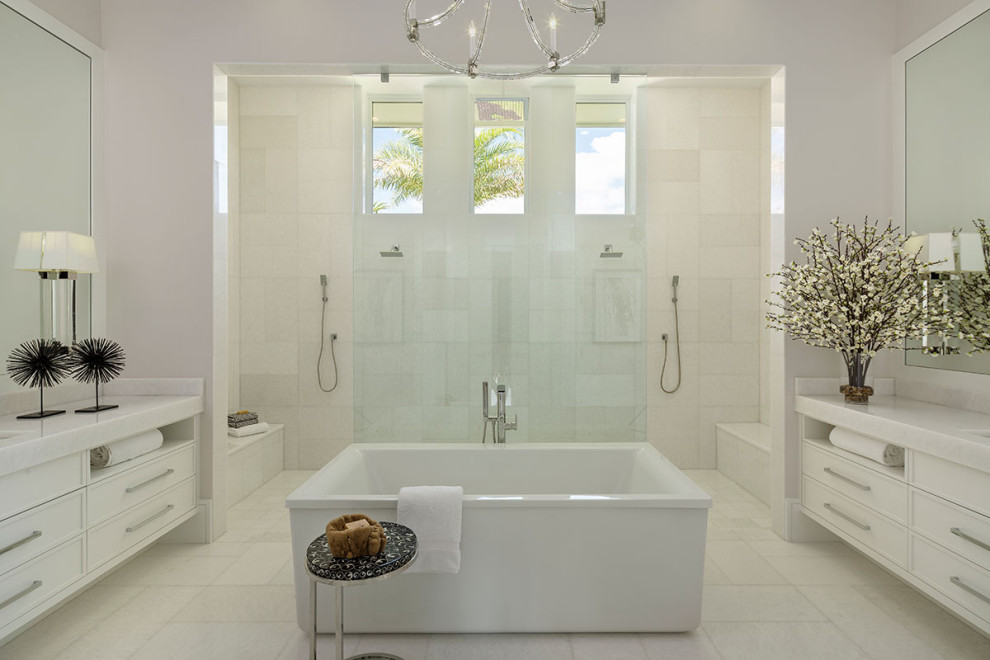 This is an example of a large mediterranean master bathroom in Miami with white cabinets, a freestanding tub and an open shower.