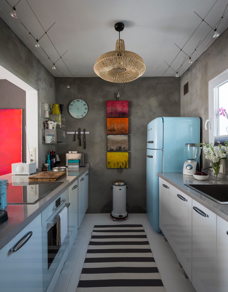 Inspiration for a small eclectic galley separate kitchen in Malaga with a drop-in sink, grey splashback, no island, flat-panel cabinets, white cabinets, solid surface benchtops, ceramic floors, coloured appliances and grey benchtop.