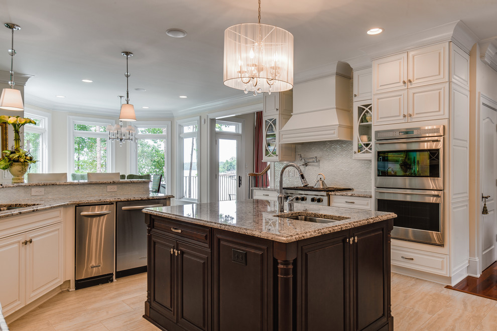 Large traditional eat-in kitchen in Charlotte with raised-panel cabinets, white cabinets, grey splashback, stainless steel appliances, an undermount sink, granite benchtops, with island and beige floor.