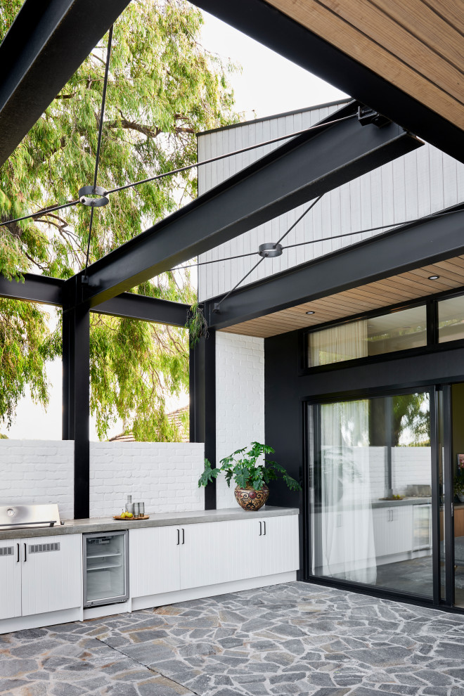 Mid-sized contemporary one-storey brown house exterior in Geelong with a clipped gable roof, a metal roof and wood siding.