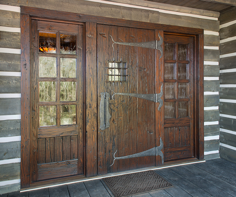 This is an example of an expansive country front door in Denver with dark hardwood floors, a single front door and a dark wood front door.