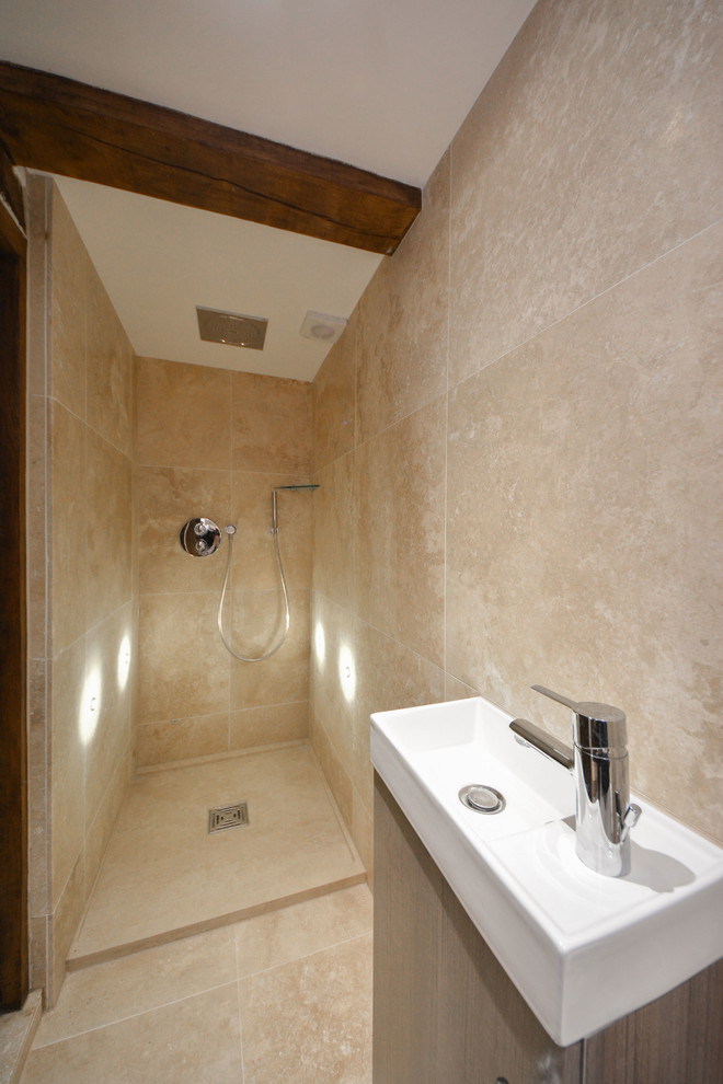 Design ideas for a small country 3/4 bathroom in Kent with a console sink, flat-panel cabinets, an open shower, a wall-mount toilet, beige tile, beige walls, travertine floors, medium wood cabinets and limestone.