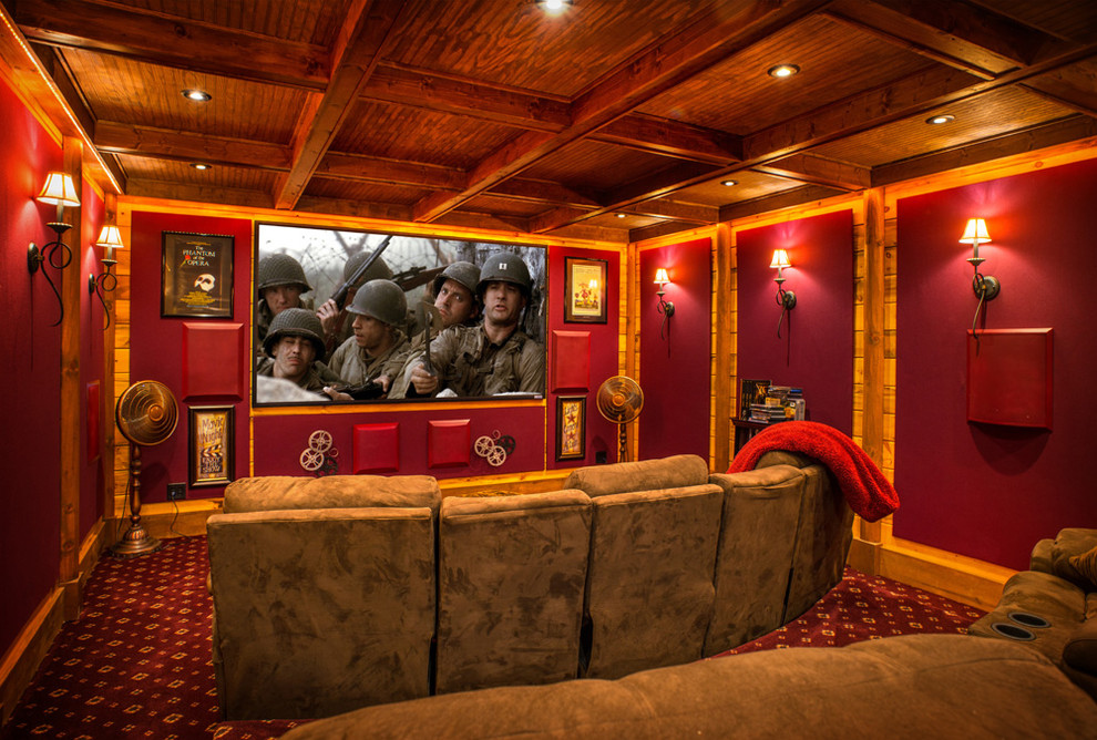 This is an example of a mid-sized country enclosed home theatre in Huntington with red walls, carpet, a projector screen and multi-coloured floor.