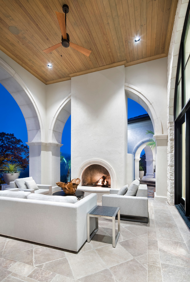 Inspiration for an expansive transitional backyard patio in Austin with tile, a roof extension and with fireplace.