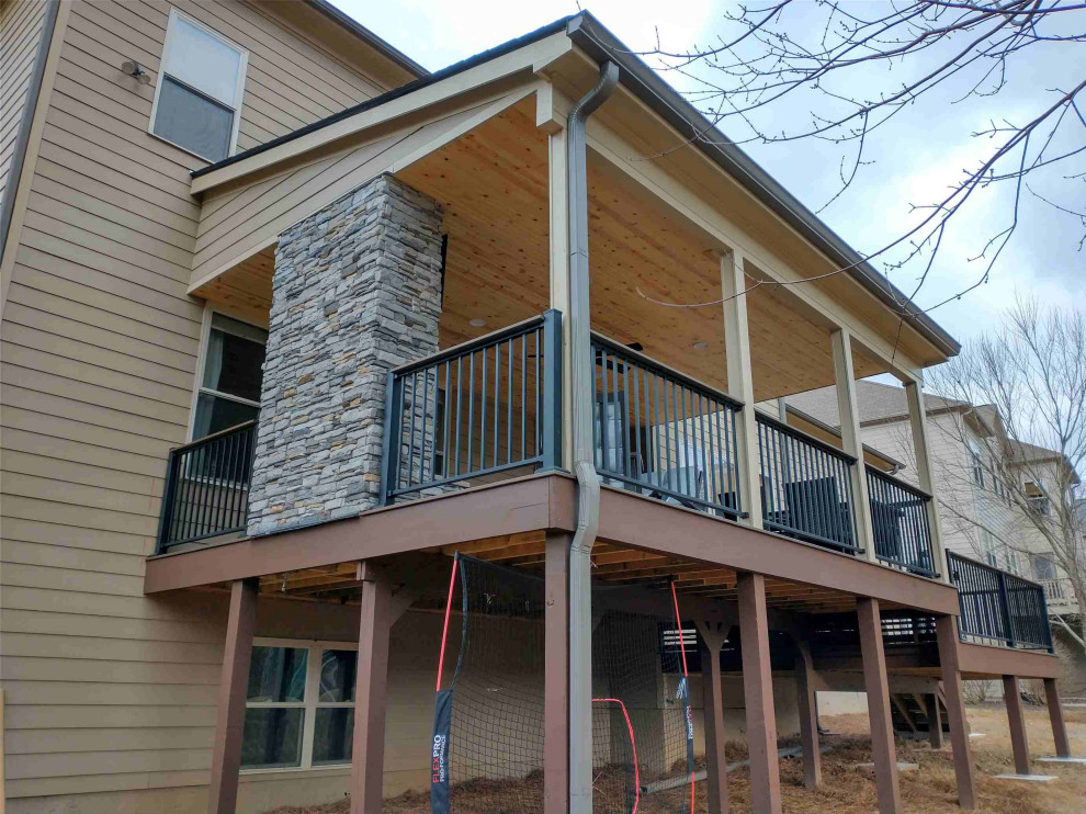 Inspiration for a mid-sized timeless backyard metal railing deck remodel in Atlanta with a fireplace and a roof extension