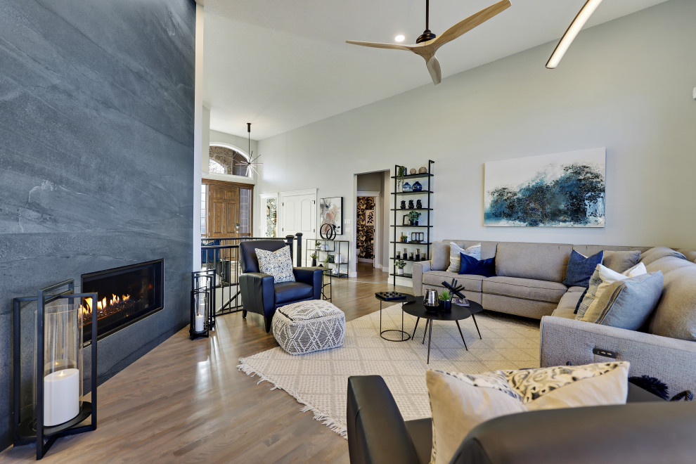 Photo of a large contemporary formal open concept living room in Calgary with white walls, medium hardwood floors, a corner fireplace, no tv, beige floor and a tile fireplace surround.