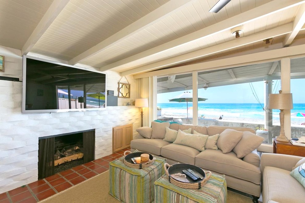 This is an example of a mid-sized beach style open concept living room in San Diego with white walls, a standard fireplace and a brick fireplace surround.