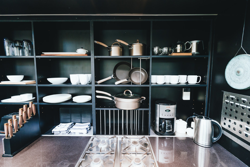 Photo of a mid-sized contemporary single-wall kitchen pantry in Sydney with an undermount sink, flat-panel cabinets, brown cabinets, marble benchtops, black splashback, timber splashback, stainless steel appliances, ceramic floors, with island, black floor and black benchtop.