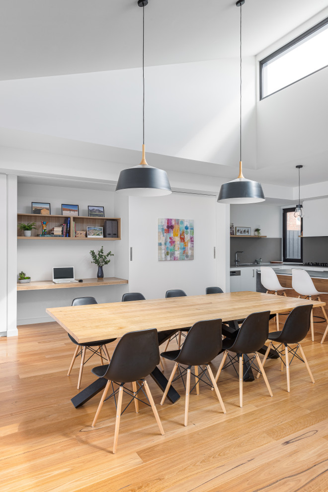 Idee per una sala da pranzo contemporanea con pareti bianche, pavimento in legno massello medio, pavimento marrone e soffitto a volta