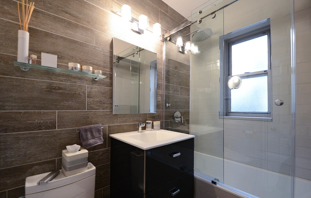 Inspiration for a small modern master bathroom in New York with flat-panel cabinets, dark wood cabinets, a drop-in tub, an open shower, a one-piece toilet, brown tile, brown walls, ceramic floors, engineered quartz benchtops, grey floor, a sliding shower screen and white benchtops.