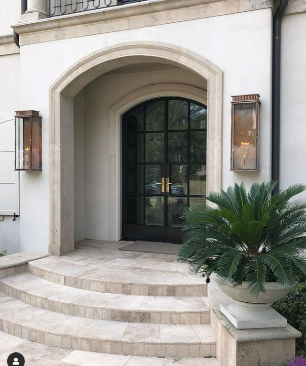 Diseño de puerta principal abovedada minimalista de tamaño medio con paredes beige, suelo de baldosas de terracota, puerta doble, puerta negra y suelo beige