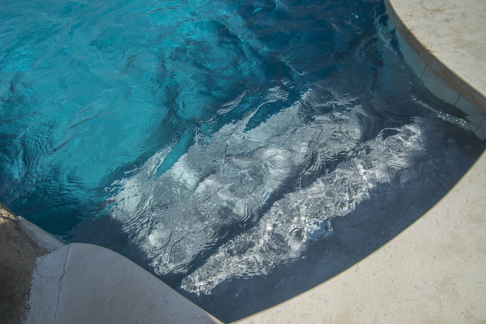 Hot tub - large backyard stone and custom-shaped hot tub idea in Chicago