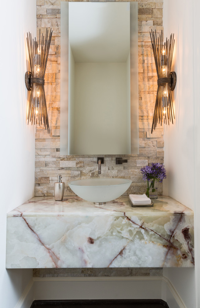 This is an example of a contemporary powder room in Houston with beige tile, stone tile, white walls, dark hardwood floors, a vessel sink, marble benchtops and white benchtops.