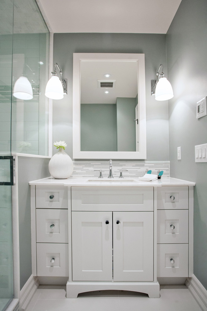 Small transitional bathroom in Toronto with an undermount sink, shaker cabinets, white cabinets, marble benchtops, a two-piece toilet, white tile, porcelain tile, blue walls and porcelain floors.