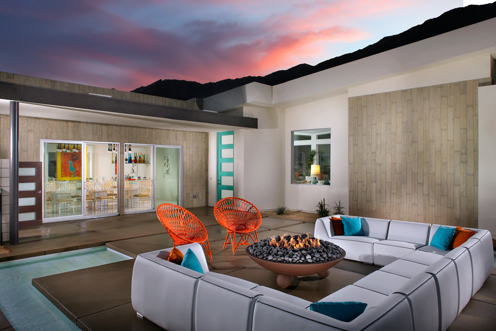 Mid-century modern patio photo in Los Angeles with a fire pit and no cover