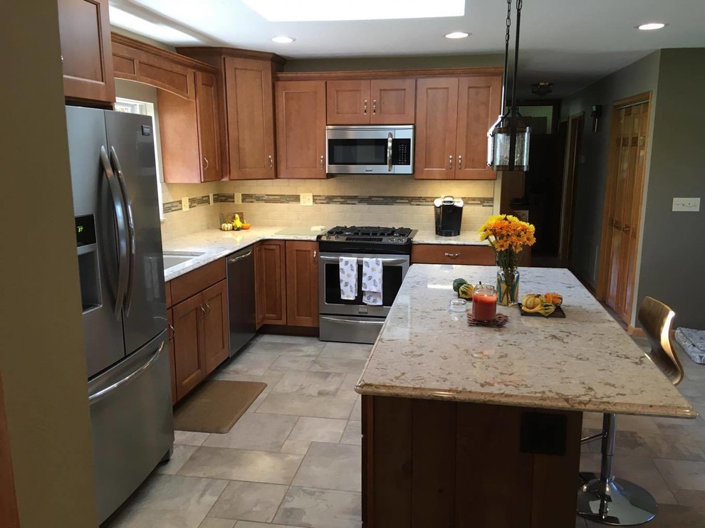 Example of a mid-sized transitional l-shaped porcelain tile and multicolored floor eat-in kitchen design with an undermount sink, recessed-panel cabinets, medium tone wood cabinets, quartz countertops, beige backsplash, porcelain backsplash, stainless steel appliances and an island