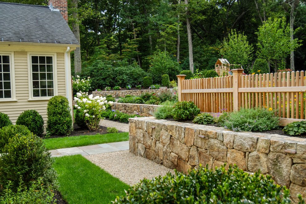 Design ideas for a mid-sized traditional backyard full sun garden in Boston with a retaining wall and gravel.