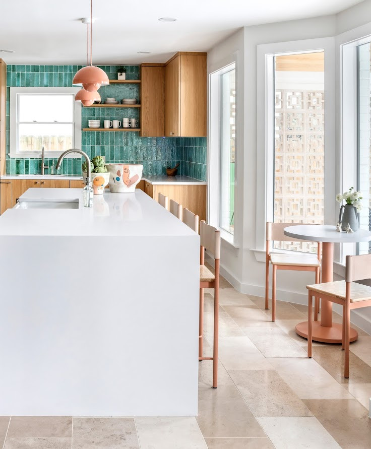 Small modern l-shaped kitchen/diner in Austin with an island, a built-in sink, flat-panel cabinets, medium wood cabinets, glass worktops, blue splashback, ceramic splashback, integrated appliances, light hardwood flooring, brown floors, white worktops and a drop ceiling.