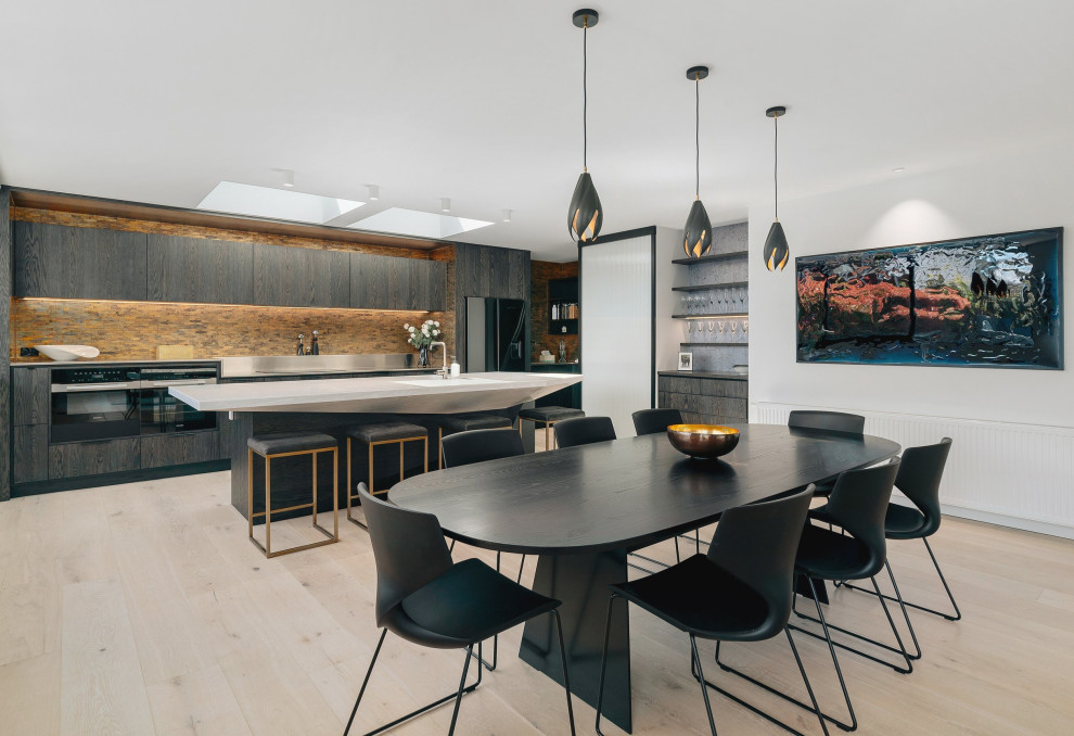 This is an example of a large modern galley eat-in kitchen in Other with an integrated sink, black appliances, light hardwood floors and with island.