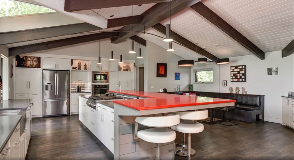 Inspiration for a large eclectic u-shaped eat-in kitchen in Other with a farmhouse sink, flat-panel cabinets, white cabinets, quartz benchtops, stainless steel appliances, concrete floors and with island.