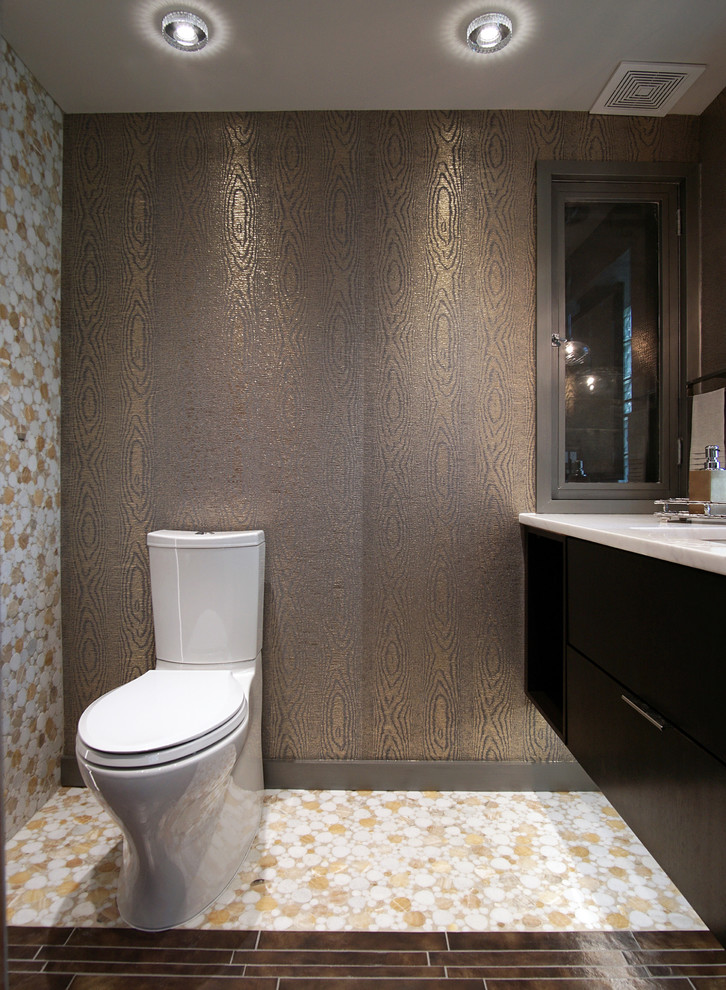 This is an example of a small contemporary powder room in Chicago with a two-piece toilet, mosaic tile, flat-panel cabinets, dark wood cabinets, multi-coloured tile, mosaic tile floors, an undermount sink, granite benchtops, multi-coloured walls and white benchtops.