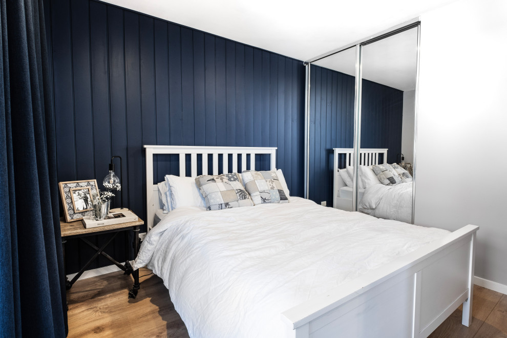 Mid-sized modern master bedroom in Melbourne with white walls, laminate floors, brown floor and panelled walls.