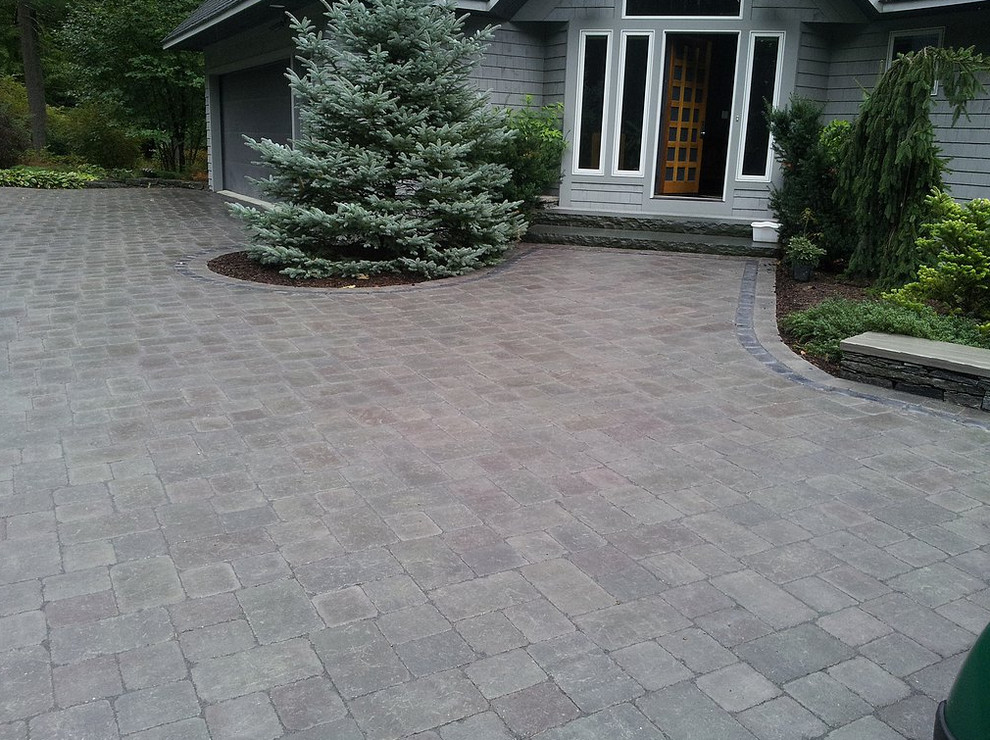 Large traditional front yard driveway in Burlington with natural stone pavers.