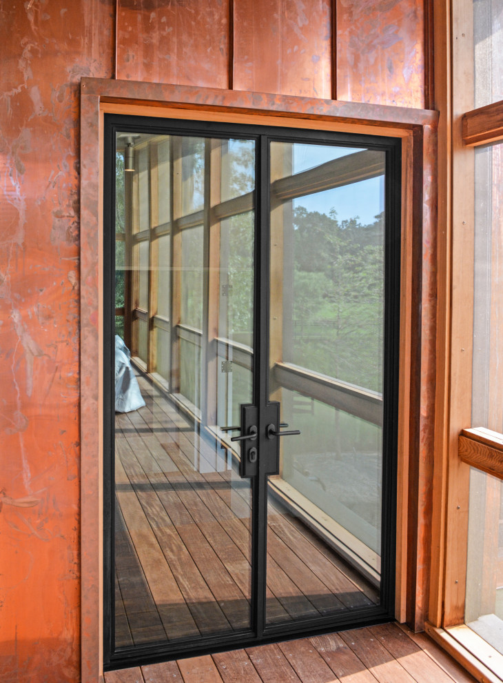 Entry hall - huge medium tone wood floor and red floor entry hall idea with metallic walls and a black front door
