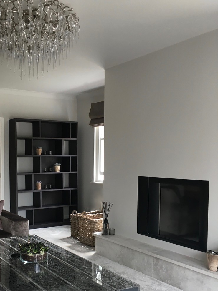 This is an example of a mid-sized contemporary formal enclosed living room in West Midlands with grey walls, carpet, a wood stove, a plaster fireplace surround and a freestanding tv.