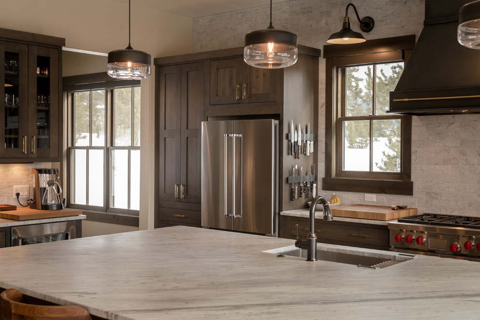 Open concept kitchen - large rustic l-shaped light wood floor and beige floor open concept kitchen idea in Denver with an undermount sink, shaker cabinets, dark wood cabinets, quartz countertops, beige backsplash, subway tile backsplash, stainless steel appliances, an island and white countertops