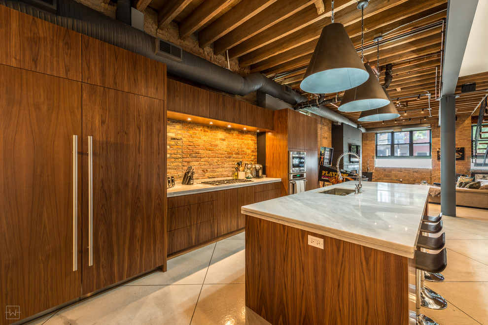 This is an example of a large country eat-in kitchen in Chicago with an undermount sink, flat-panel cabinets, medium wood cabinets, marble benchtops, panelled appliances, concrete floors and with island.
