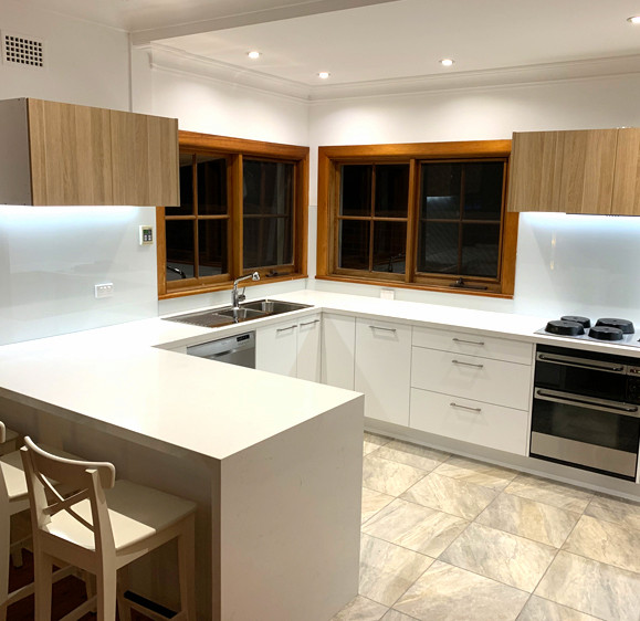 Inspiration for a contemporary kitchen in Sydney with white splashback and glass sheet splashback.