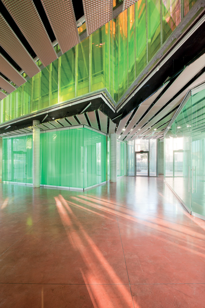 Geräumiges Modernes Foyer mit bunten Wänden, Betonboden, Drehtür und rotem Boden in Mailand