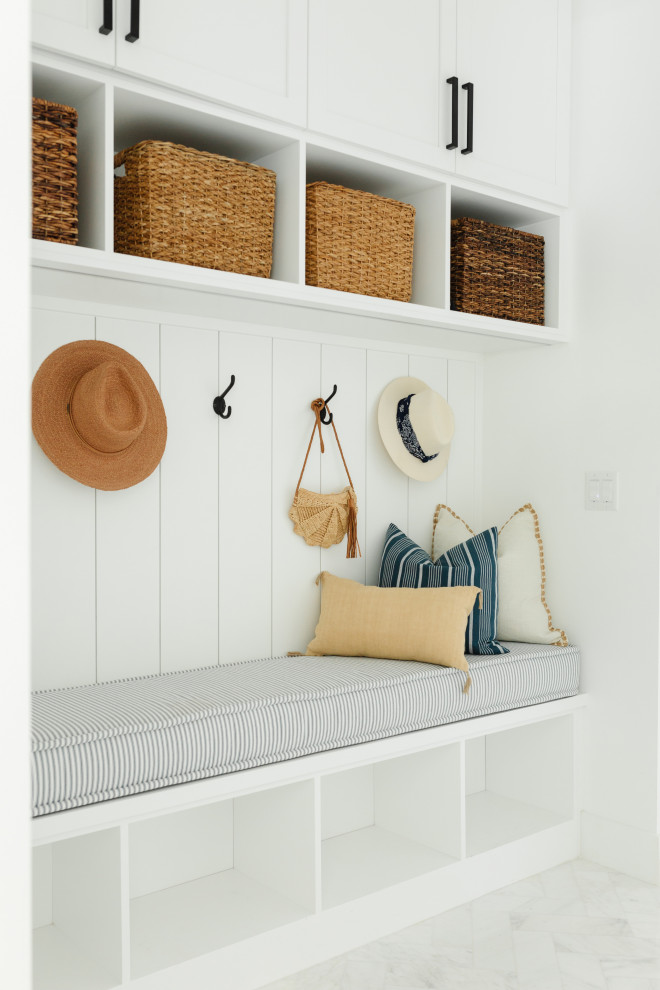 Photo of a large beach style mudroom in Miami with white walls, marble floors, white floor and planked wall panelling.