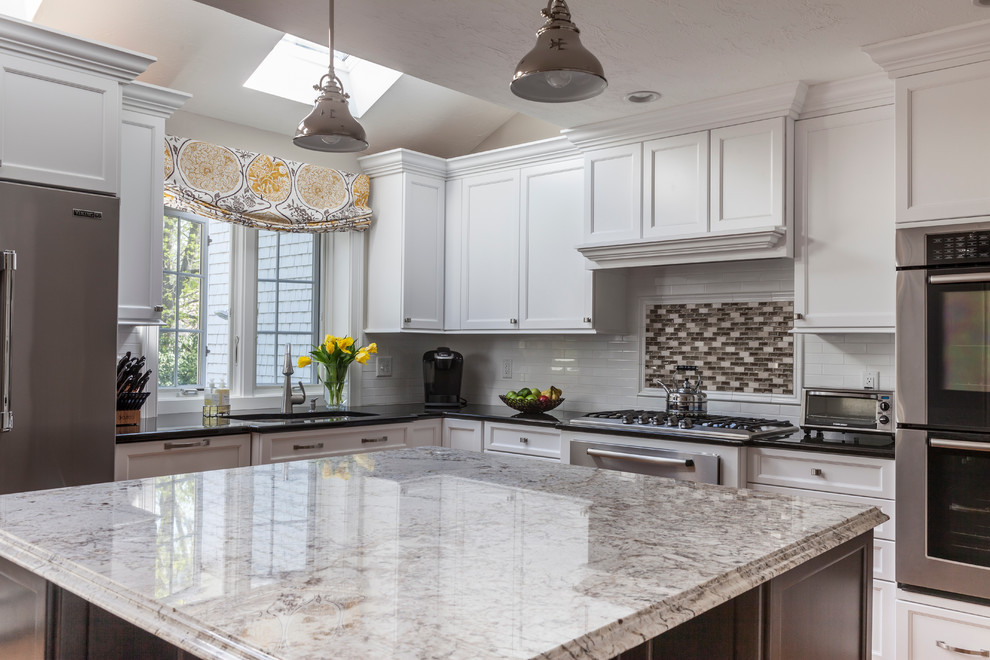 Design ideas for a transitional l-shaped eat-in kitchen in Boston with a double-bowl sink, shaker cabinets, white cabinets, granite benchtops, white splashback, subway tile splashback and stainless steel appliances.