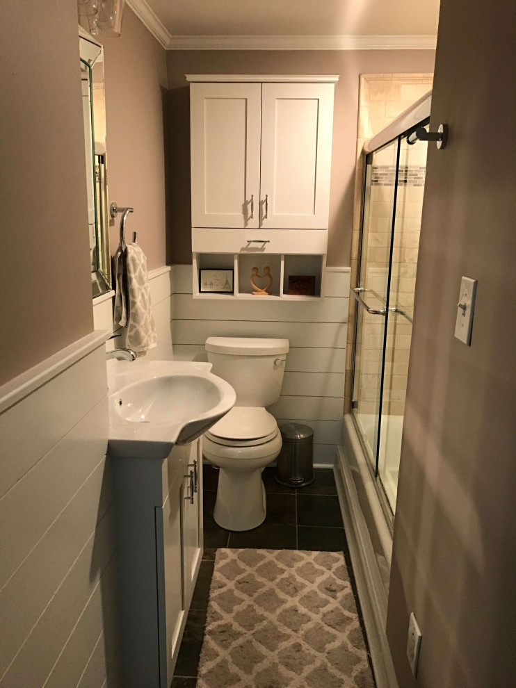 Small transitional 3/4 bathroom in DC Metro with recessed-panel cabinets, white cabinets, an undermount tub, a shower/bathtub combo, a one-piece toilet, beige tile, travertine, beige walls, slate floors, a console sink, glass benchtops, brown floor, a sliding shower screen, white benchtops, a niche, a single vanity, a built-in vanity and decorative wall panelling.