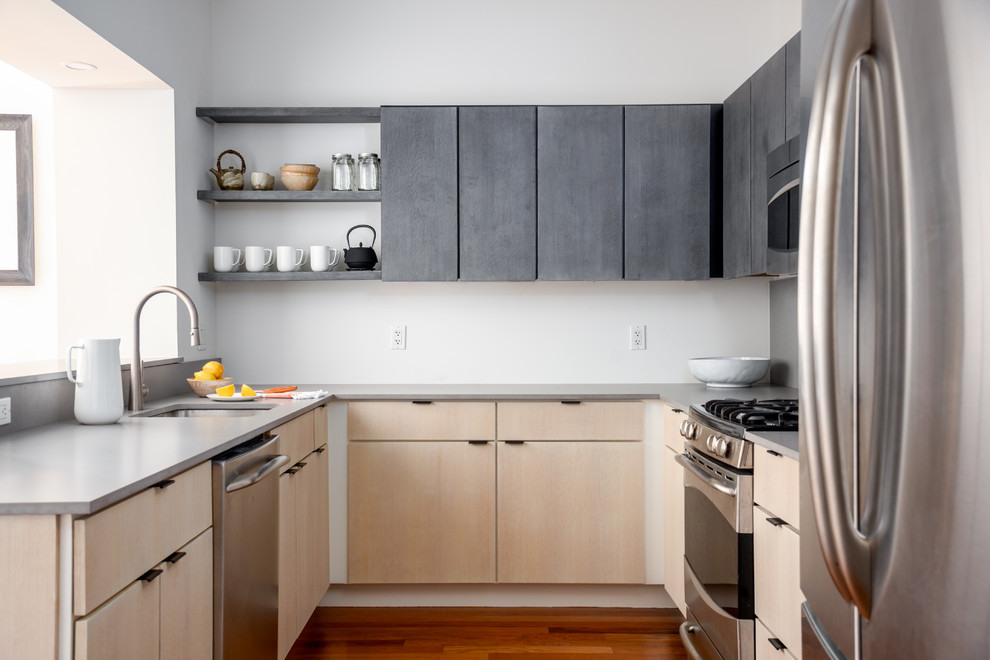 This is an example of a mid-sized contemporary u-shaped separate kitchen in Boston with a single-bowl sink, flat-panel cabinets, grey cabinets, quartz benchtops, grey splashback, stone slab splashback, stainless steel appliances, medium hardwood floors, no island, brown floor and grey benchtop.