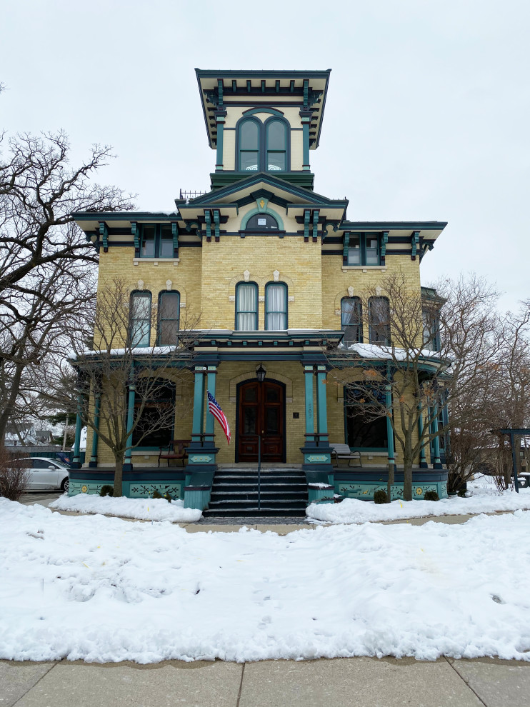 Großes, Vierstöckiges Klassisches Einfamilienhaus mit Backsteinfassade, beiger Fassadenfarbe und Blechdach in Milwaukee