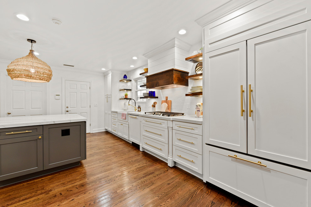 Inspiration for a mid-sized contemporary galley eat-in kitchen in Jacksonville with a farmhouse sink, shaker cabinets, white cabinets, quartz benchtops, white splashback, subway tile splashback, stainless steel appliances, medium hardwood floors, with island, brown floor and white benchtop.