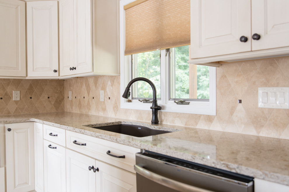 Transitional l-shaped light wood floor kitchen photo with an undermount sink, raised-panel cabinets, white cabinets, beige backsplash, stainless steel appliances, an island and beige countertops