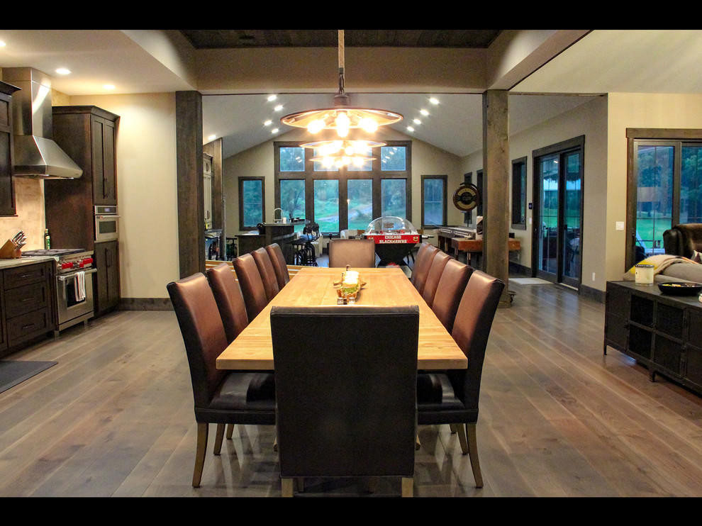 Great room - rustic medium tone wood floor and brown floor great room idea with beige walls, a standard fireplace and a stone fireplace