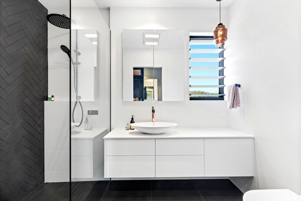 Design ideas for a mid-sized contemporary bathroom in Sunshine Coast with flat-panel cabinets, white cabinets, white tile, a vessel sink, black floor, white benchtops, an open shower, porcelain tile, white walls, porcelain floors, engineered quartz benchtops, an open shower, a single vanity and a floating vanity.