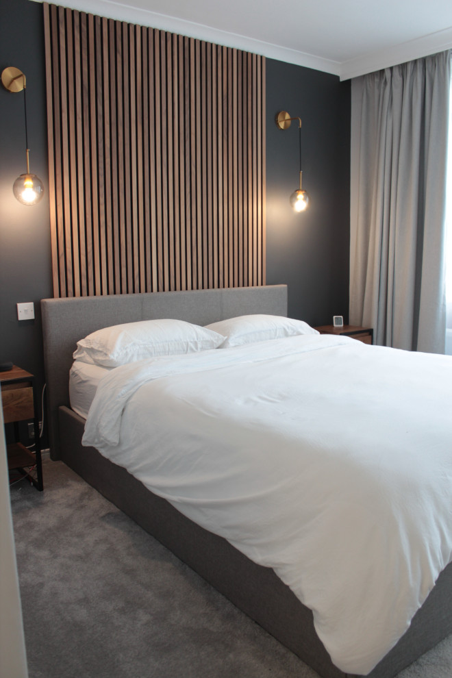 Kleines Modernes Hauptschlafzimmer mit schwarzer Wandfarbe, Teppichboden, grauem Boden und Wandpaneelen in London